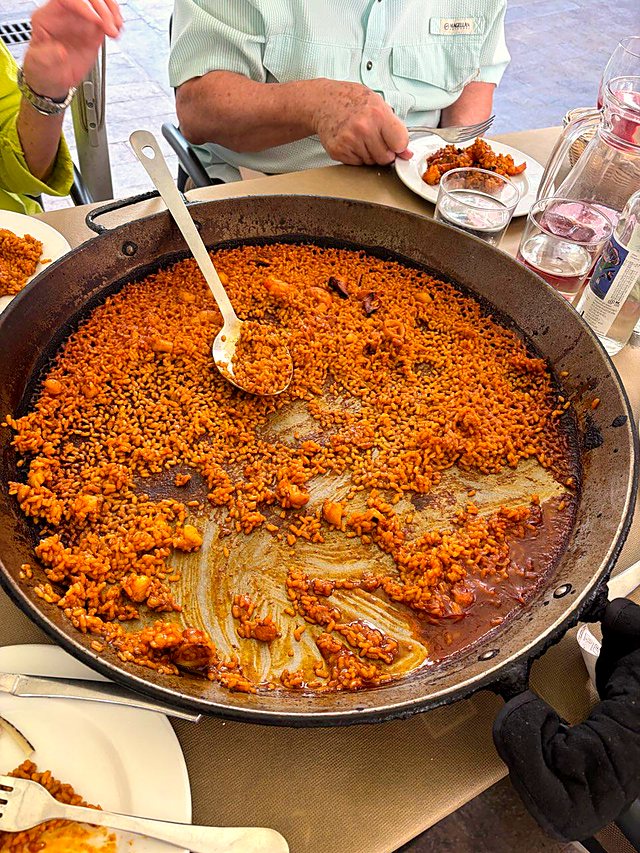 Seafood paella almost finished on a terrace table in Valencia's old town